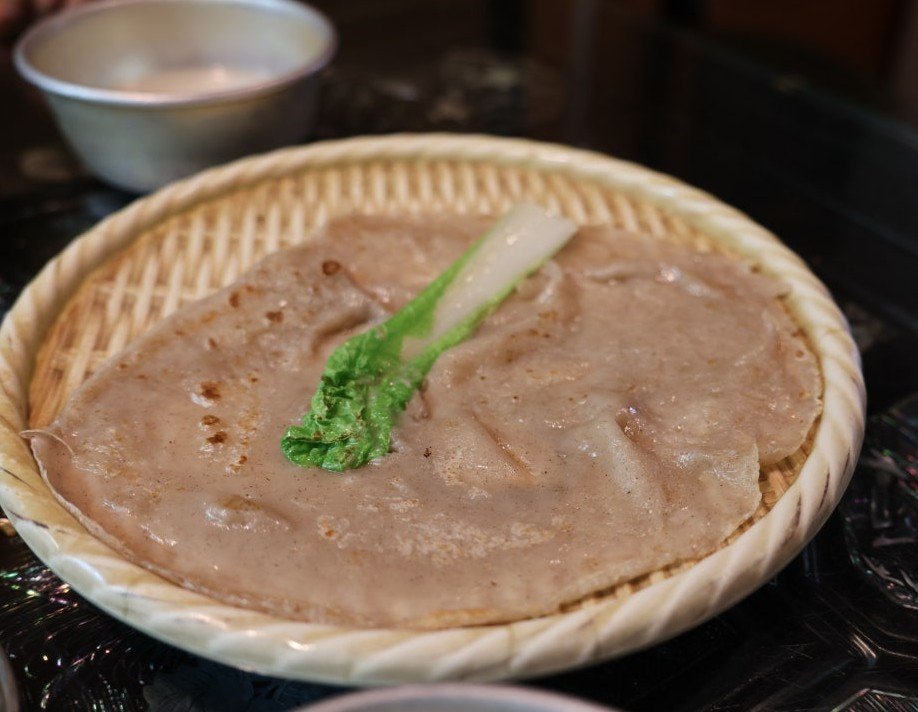 Freshly pan-fried savory buckwheat crepe (Memiljeon) at Hwangnam Ddukkeobi